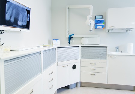 dentistry, medicine, medical equipment and stomatology concept - interior of new modern dental clinic office with chairの写真素材