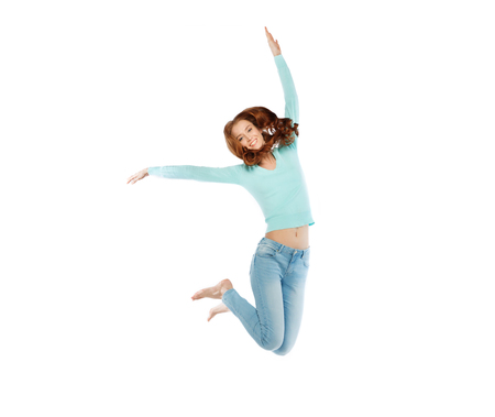 happiness, freedom, motion and people concept - smiling young woman jumping in air