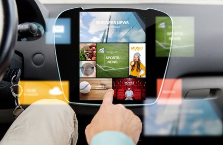 transport, driving, technology, media and people concept - close up of male hand using virtual internet applications on car computer screenの写真素材