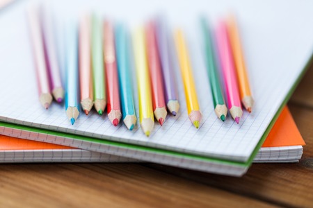 art, school, education, drawing and object concept - close up of crayons or color pencils on notebook paperの写真素材