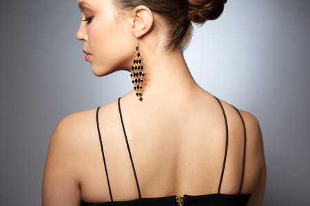 beauty, jewelry, accessories, people and luxury concept - close up of beautiful asian woman face with earring over gray backgroundの写真素材