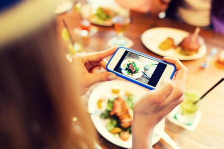 people, leisure, technology and internet addiction concept - close up of woman with smartphone...