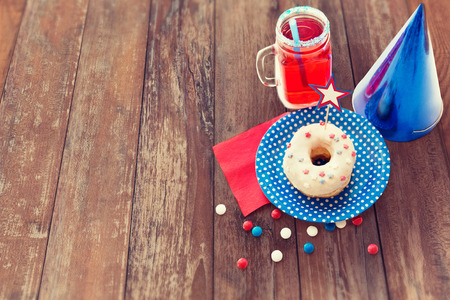american independence day, celebration, patriotism and holidays concept - close up of glazed donut decorated with star, juice and candies at 4th july party from top over wooden table backgroundの写真素材