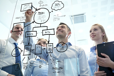 business, people, teamwork and planning concept - smiling business team with marker and stickers working in officeの写真素材