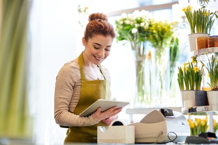 people, business, technology, sale and floristry and concept - happy smiling florist woman with...
