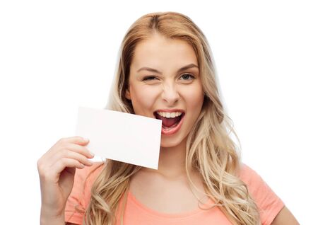 advertisement, invitation, message and people concept - smiling young woman or teenage girl with blank white paper cardの写真素材