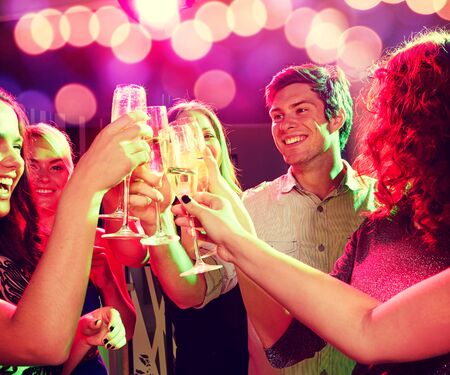 party, holidays, celebration, nightlife and people concept - smiling friends clinking glasses of...