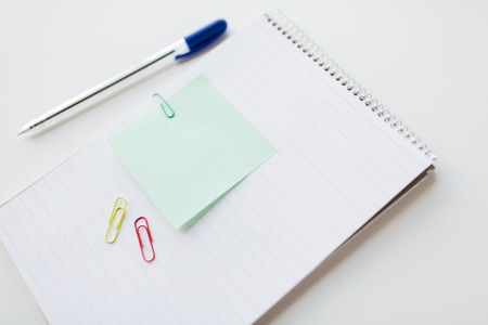 business, information, memo, management and education concept - close up of notebook with pen and bank paper on office tableの写真素材