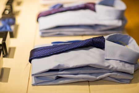 sale, shopping, male fashion, style and wear concept - close up of shirts with ties at clothing storeの写真素材