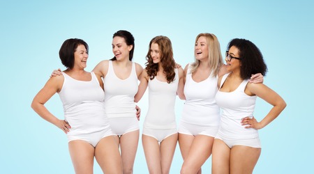 friendship, beauty, body positive and people concept - group of happy women different in white underwear over blue backgroundの写真素材