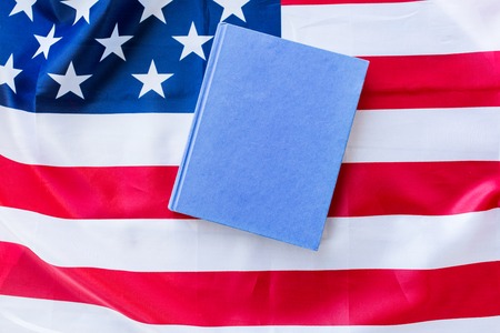american independence day, patriotism and nationalism concept - close up of american flag and book