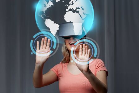 technology, virtual reality, cyberspace, entertainment and people concept - happy young woman with...
