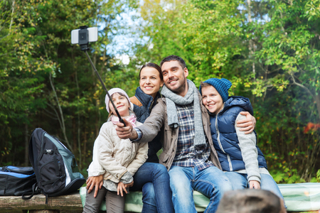 adventure, travel, tourism, hike and people concept - happy family walking with backpacks in woodsの写真素材