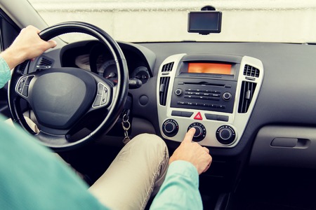 transport, road trip, car driving, technology and people concept - close up of male hand using climate control in carの写真素材