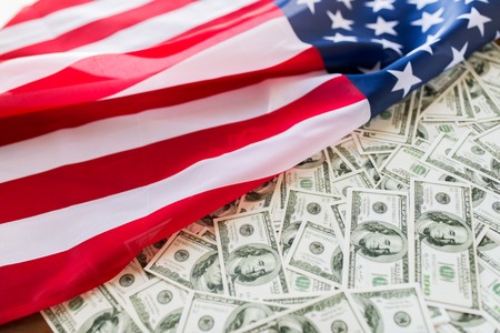state budget, finance and nationalism concept - close up of american flag and dollar cash moneyの写真素材