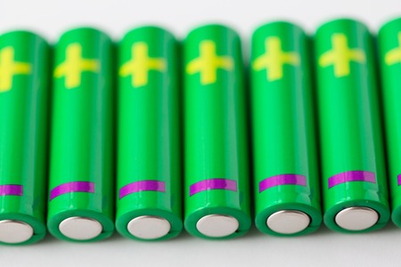 recycling, energy, power, environment and ecology concept - close up of green alkaline batteriesの写真素材