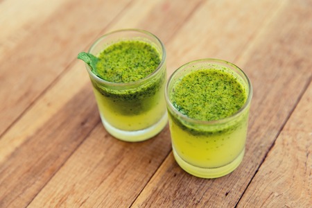 trivet, tourism, drinks and food concept - glasses of fresh juice or cocktail on table at beachの写真素材