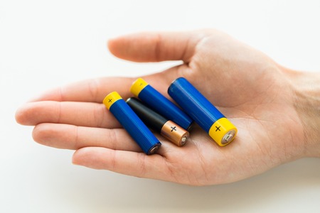 recycling, energy, power, environment and ecology concept - close up of hands holding alkaline...