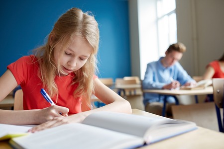 education, learning and people concept - student girl with book writing school testの写真素材