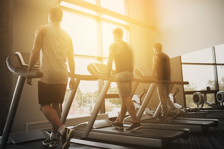 sport, fitness, lifestyle, technology and people concept - men exercising on treadmill in gym