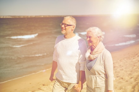 family, age, travel, tourism and people concept - happy senior couple walking along summer beachの写真素材