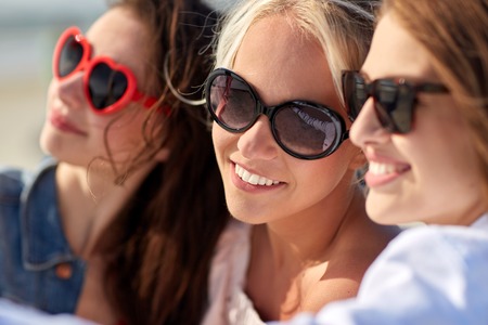summer vacation, holidays, travel and people concept- group of smiling young women taking selfie on beachの写真素材