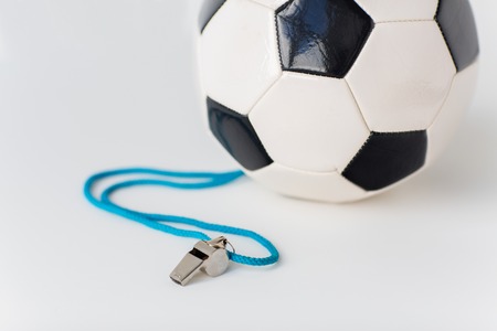 sport, soccer, football, refereeing and sports equipment concept - close up of ball and referee whistleの写真素材