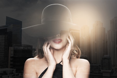 people, luxury and fashion concept - beautiful woman in black hat over dubai city with double...