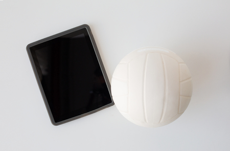 sport, fitness, game, sports equipment and technology concept - close up of volleyball ball and tablet pc computer with black blank screen on white backgroundの写真素材