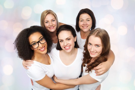 friendship, diverse, body positive and people concept - group of happy different size women in white t-shirts over holidays lights backgroundの写真素材