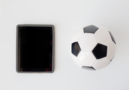 sport, football, technology and sports equipment concept - close up of soccer ball and tablet pc computer with black blank screen over white background from topの写真素材