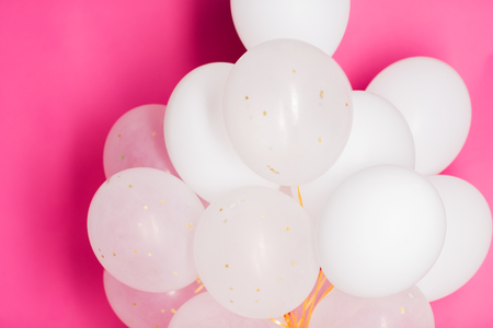 holidays, birthday, party and decoration concept - close up of inflated white helium balloons over pink backgroundの写真素材