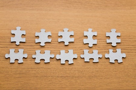 business and connection concept - close up of puzzle pieces on wooden surfaceの写真素材