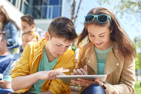 education, high school and people concept - group of happy teenage students with tablet pc computers...