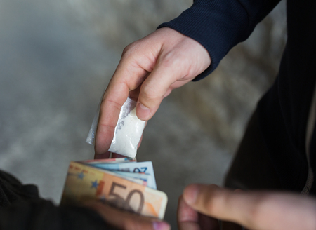 drug trafficking, crime, addiction and sale concept - close up of addict with money buying dose from dealer on streetの写真素材