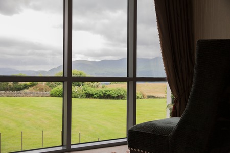 travel, tourism and summer holidays concept - view from window to natural irish lanscape at country houseの写真素材