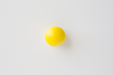 sport, fitness, game, sports equipment and objects concept - close up of yellow golf ball over white background from topの写真素材