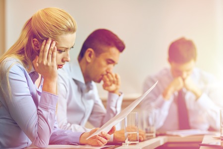 business, teamwork, people and crisis concept - business team sitting sad and solving problem in officeの写真素材