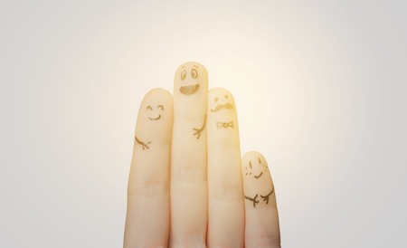 gesture, family, people and body parts concept - close up of two hands showing fingers with smiley facesの写真素材