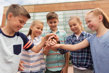primary education, friendship, childhood and people concept - group of happy elementary school...