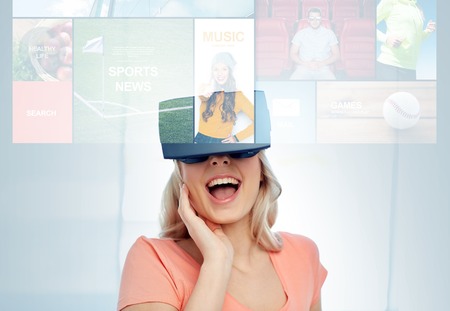 technology, augmented reality, cyberspace, entertainment and people concept - happy amazed young woman with virtual headset or 3d glasses at home looking at news projectionの写真素材