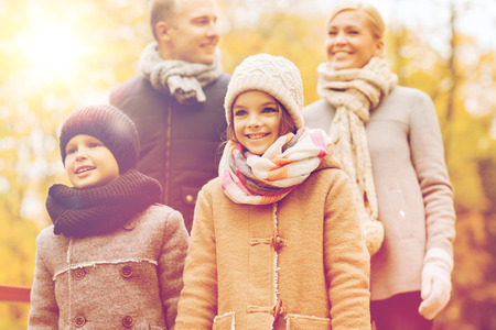 family, childhood, season and people concept - happy family in autumn parkの写真素材