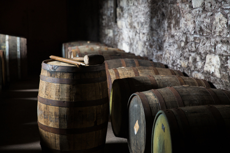 storage, container, winery, brewery and object concept - close up of old wooden barrel in wine...
