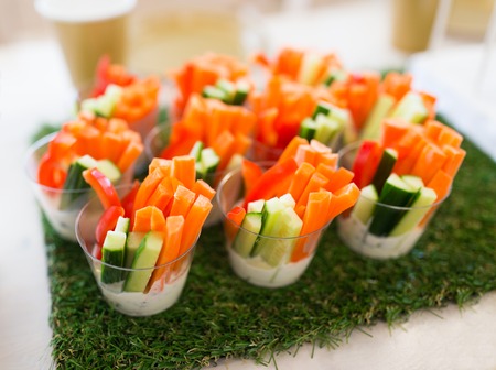 healthy eating, vegetarian food, diet and culinary concept - close up of vegetable snacks on table decorated with artificial grassの写真素材