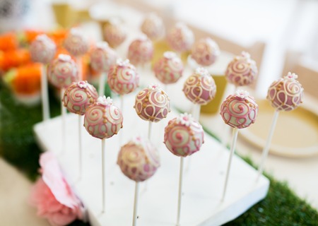 food, sweets, junk-food, holidays and celebration concept - close up of cake pops or lollipops on party tableの写真素材