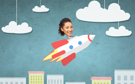 business, startup, development and people concept - businesswoman flying on rocket above cartoon cityの写真素材