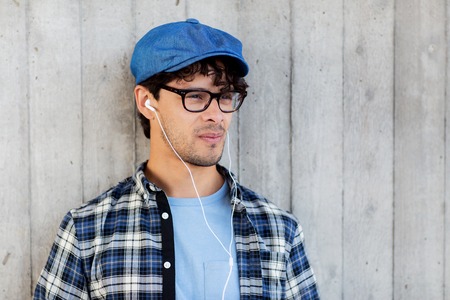 people, music, leisure and lifestyle - man with earphones listening to music on streetの写真素材