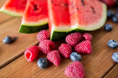 healthy eating, food, dieting and vegetarian concept - close up of raspberry, blackberry and watermelon slices on wooden tableの写真素材