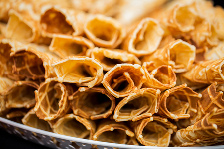 food, baking, cooking and eating concept - close up of waffle cones or rollsの写真素材