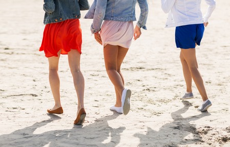 summer vacation, holidays, travel and people concept - close up of women legs running on beachの写真素材